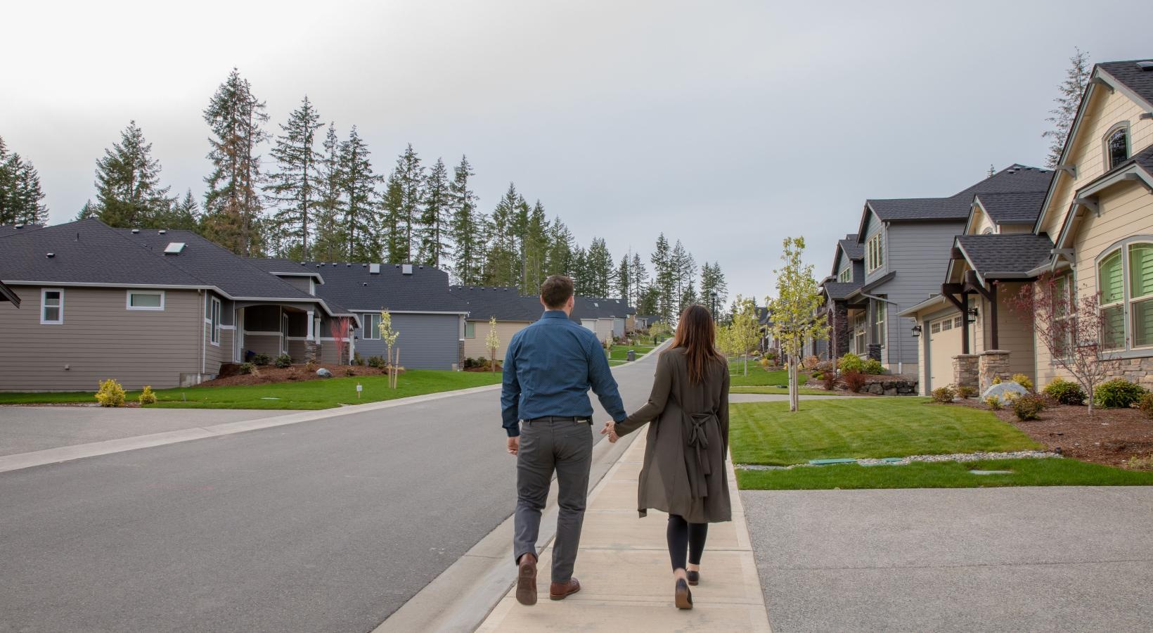 Find your perfect fit at The Residences at McCormick Village a man and woman walking down a sidewalk in front of houses