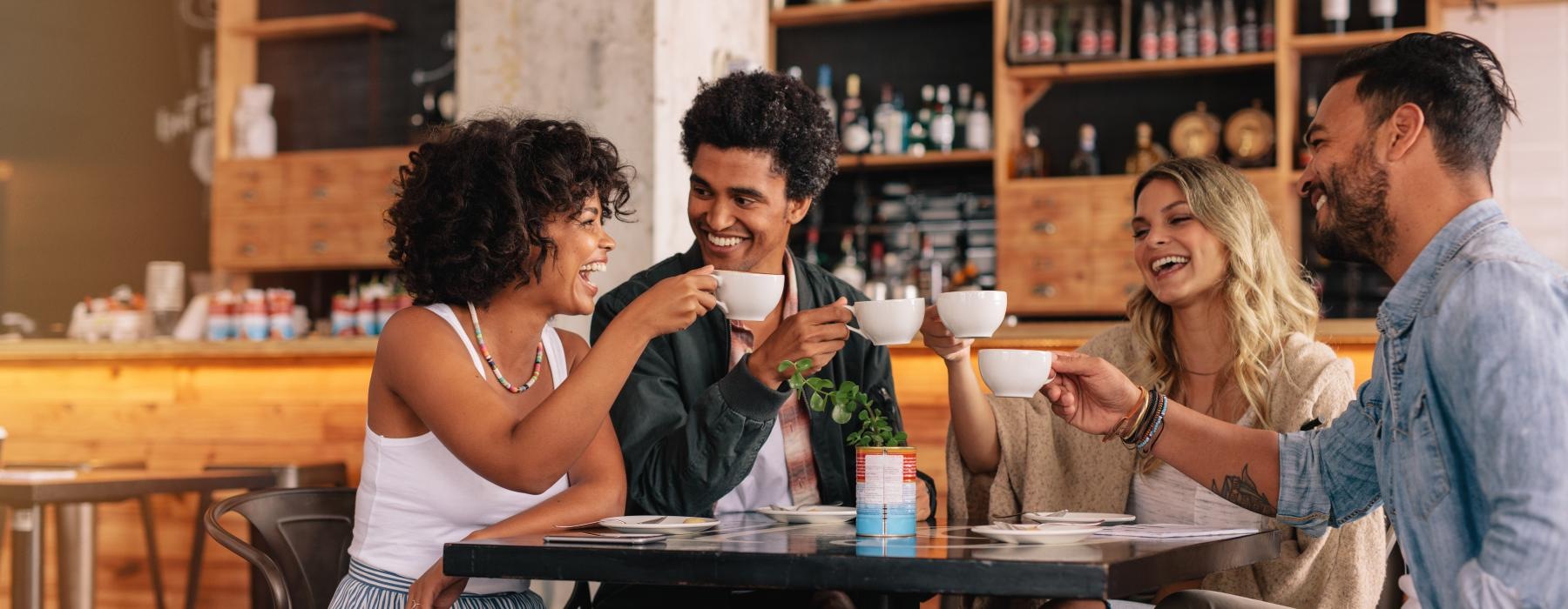 a group of people sitting at a table with cups of coffee